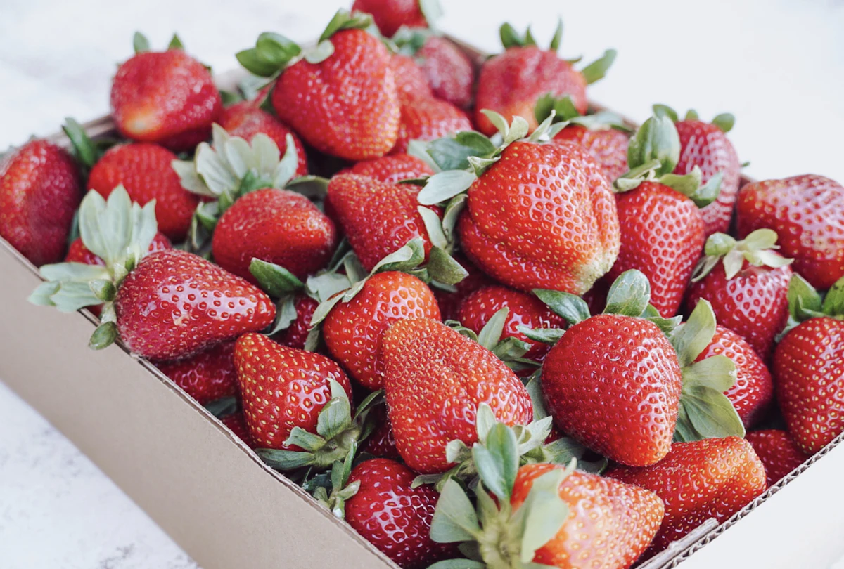 Ilustrasi strawberry premium dalam kotak karton putih